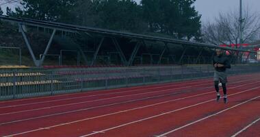 un hombre es corriendo en un pista en un estadio video