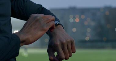 A man is checking his watch on a soccer field video