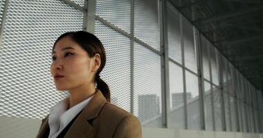 A woman in a business suit standing in front of a window video