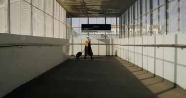 A man walking down an empty hallway with a suitcase video