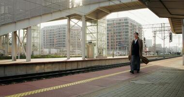 A man in a suit and tie is walking on the platform video