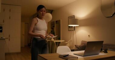 A woman standing in front of a laptop and a table video