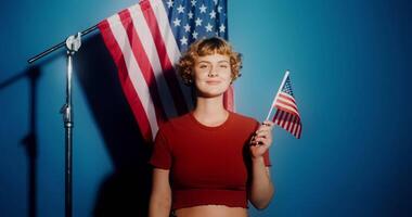 A woman holding an american flag in front of a microphone video