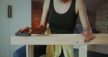 A woman is working on a table with a sanding block video