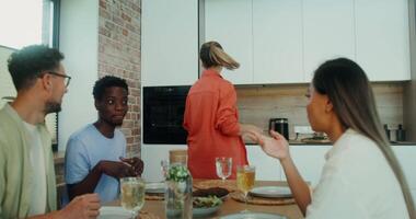 A group of people sitting at a table in a kitchen video
