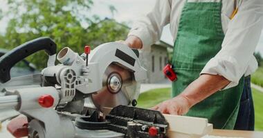 A man with an apron and apron is using a circular saw video
