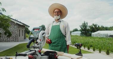 A man in a straw hat and apron is standing in front of a table with a circular video