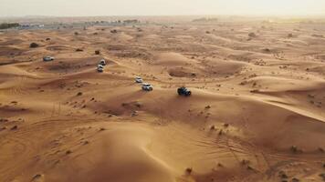 A group of vehicles in the desert with sand dunes video