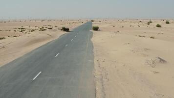 An empty road in the desert with sand dunes video
