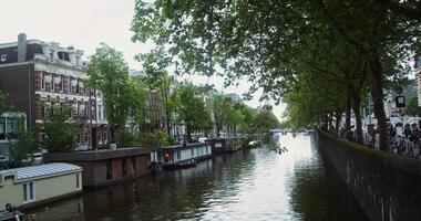 A canal with many boats on it and buildings in the background video