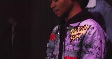 A man in a jacket with a microphone and a microphone video