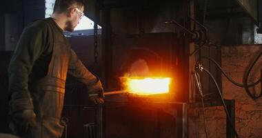 A man is working on a furnace with a hot object video