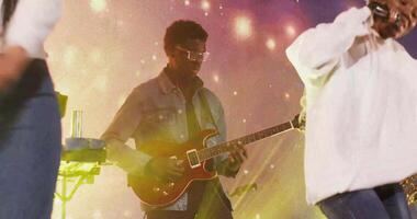 A man in a white shirt playing guitar on stage video