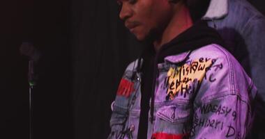 A man in a jacket with a microphone and a microphone video