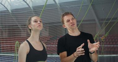 A man and woman standing in front of a net video