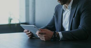 A man in a suit is using a tablet computer video