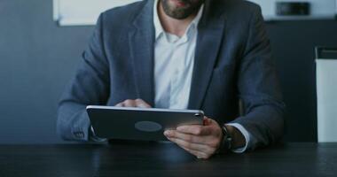 A man in a suit is using a tablet computer video
