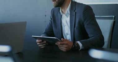A man in a suit is using a tablet computer video