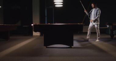 A man standing in front of a pool table video