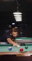 A man leaning over a pool table with a cue stick video