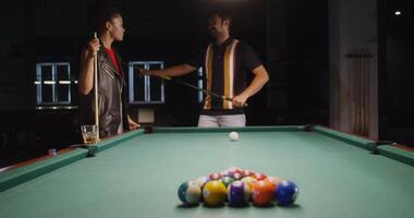A man and woman playing pool in a bar video