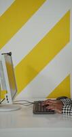 A woman sitting at a desk with a keyboard and a computer video