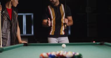 Two men standing around a pool table with balls video