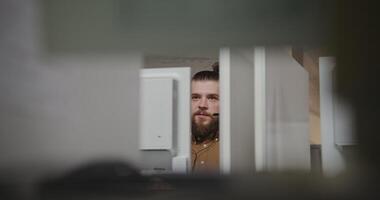 A man with a beard and a headset in an office video