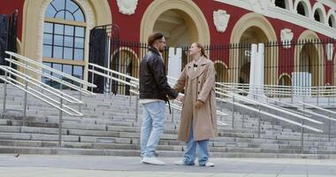 A man and woman are standing on steps in front of a building video