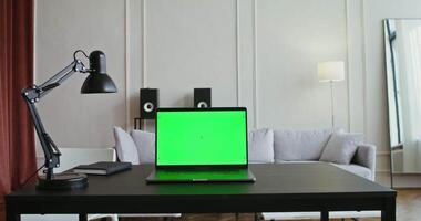 A laptop with a green screen on a table video