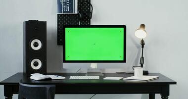 A computer with a green screen on a desk video