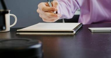 A person is writing on a notebook with a pen video