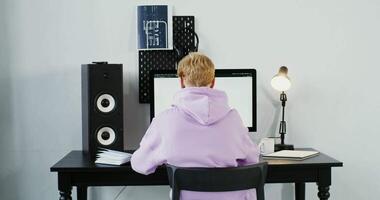 A person sitting at a desk with a computer video