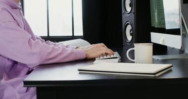 A person sitting at a desk with a computer and keyboard video