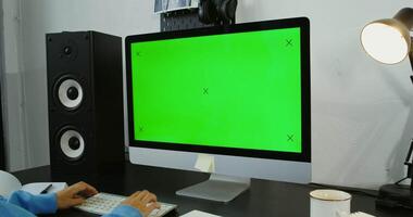 un persona es utilizando un computadora con un verde pantalla video