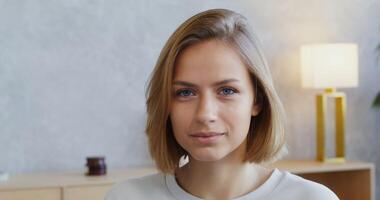 A woman is looking at the camera while sitting in an office video