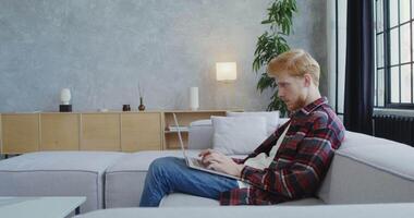 A man sitting on a couch using a tablet computer video