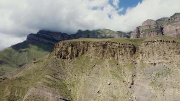 A mountain with a large cliff on top video