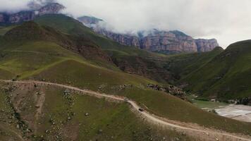 A dirt road in the mountains with a mountain range in the background video