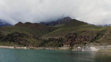 A lake surrounded by mountains and clouds video