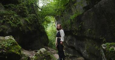 A woman standing in a narrow canyon between two rocks video