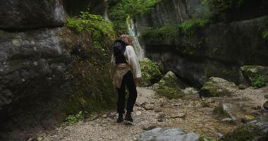 A woman walking through a narrow path in the woods video