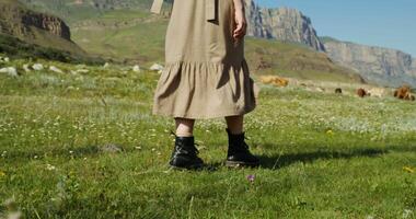 A woman in a dress and boots standing in a field video