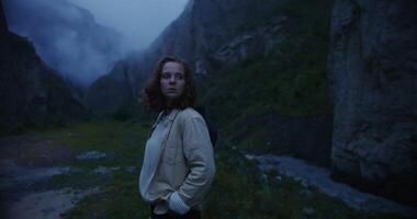 A woman standing in front of a mountain video