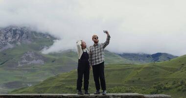 Two people taking a selfie in front of a mountain video