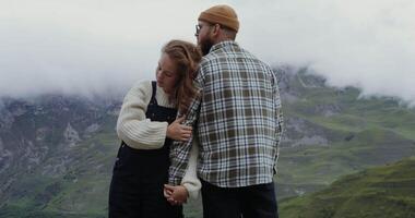 Couple standing on top of mountain with clouds in the background video