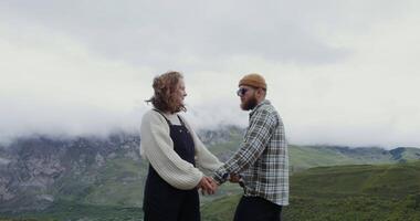 Couple holding hands in front of mountains video