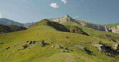 A mountain range with a grassy hill and a few cows video