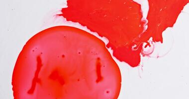 A red and white paint splattered on a white surface video