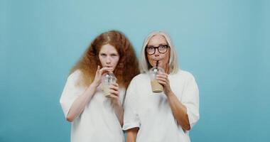 Two women with glasses drinking from a glass video